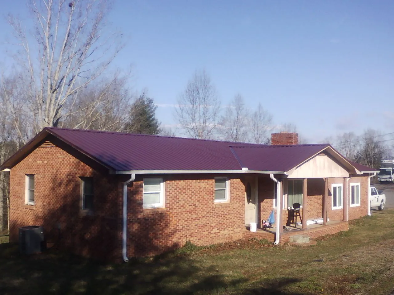 Burgundy metal roof on a brick ranch home with a new addition in Redmond