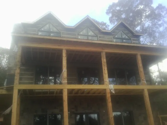 Dormers and porch framing on a large log home under construction — Roof Coating work by our crew in Redmond